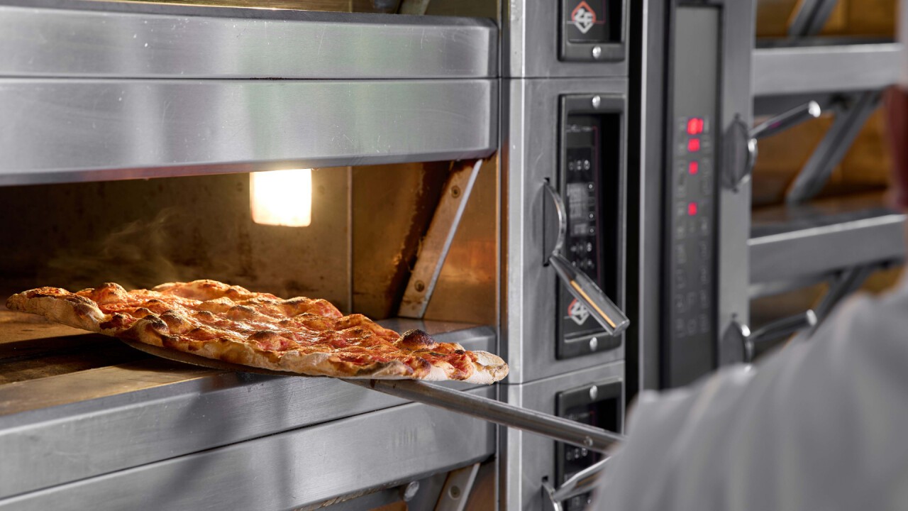 Baked to perfection: the smoking "pizza romana" exits from our MODULAR 4T 40x60. In the background, a detail of our cyclothermic deck oven SCT3.