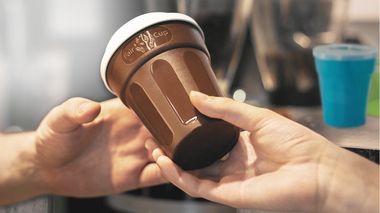 Ein FairCup (Mehrweg Pfandbecher) wird über den Tresen gereicht