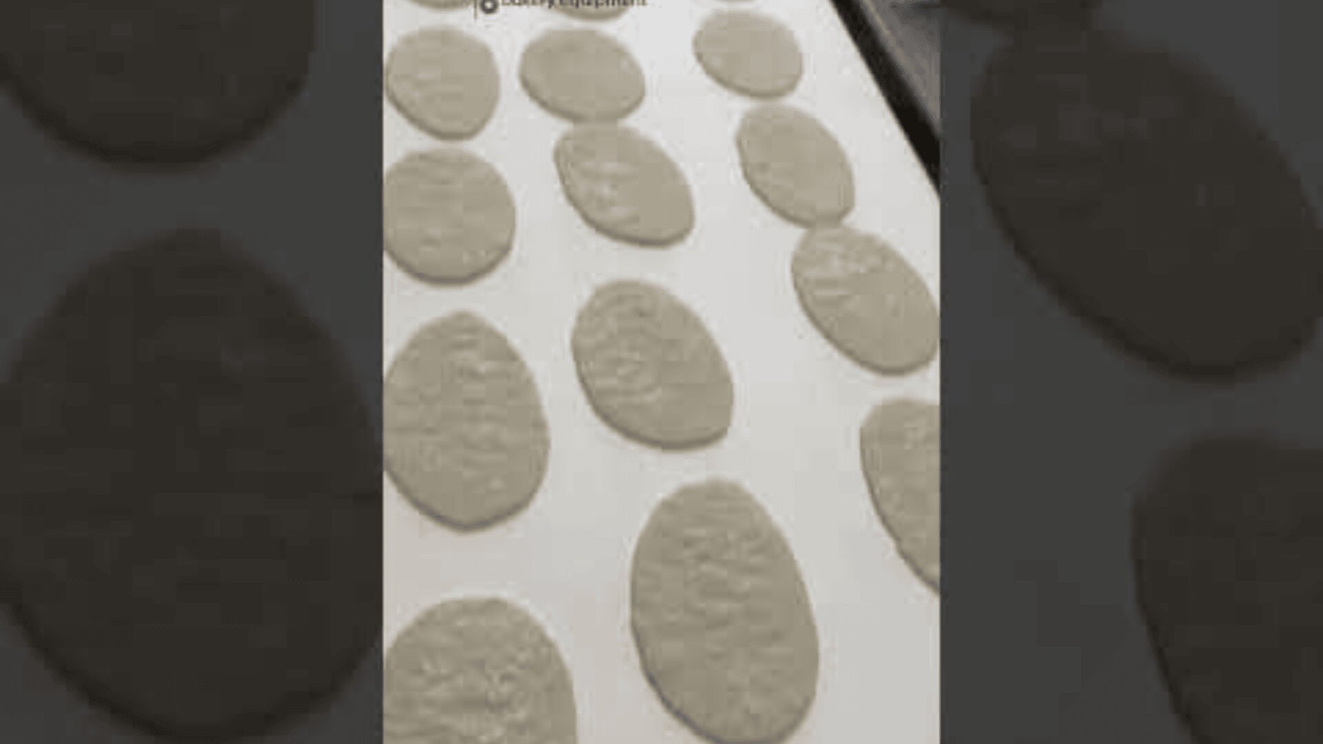 The oval pieces of dough are spread out on a baking tray lined with parchment paper and are ready to bake.