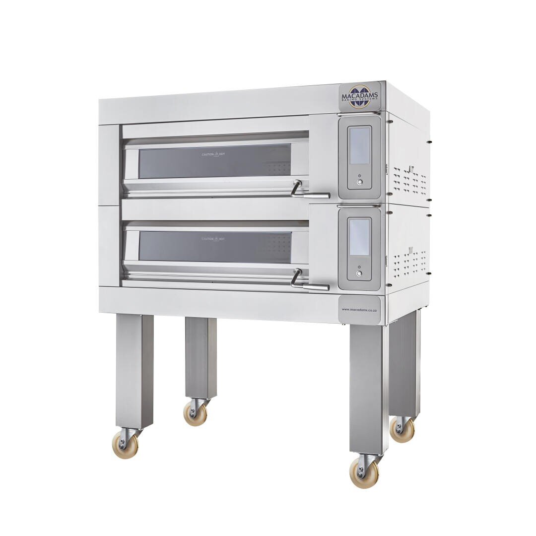 A commercial double deck stainless steel oven on four legs with wheels, with glass windows on each deck and digital control panels on the right side of the two compartments.