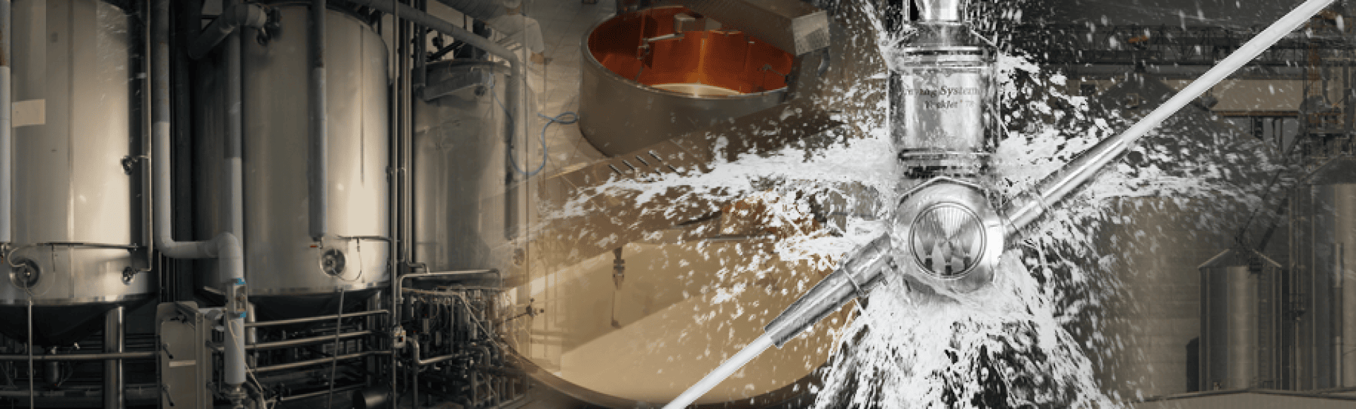 Eine Nahaufnahme von Industriemaschinen mit großen Metalltanks links und einem Hochdruckwasserrohr rechts. Im Hintergrund sind weitere Geräte und Industriearmaturen zu sehen.