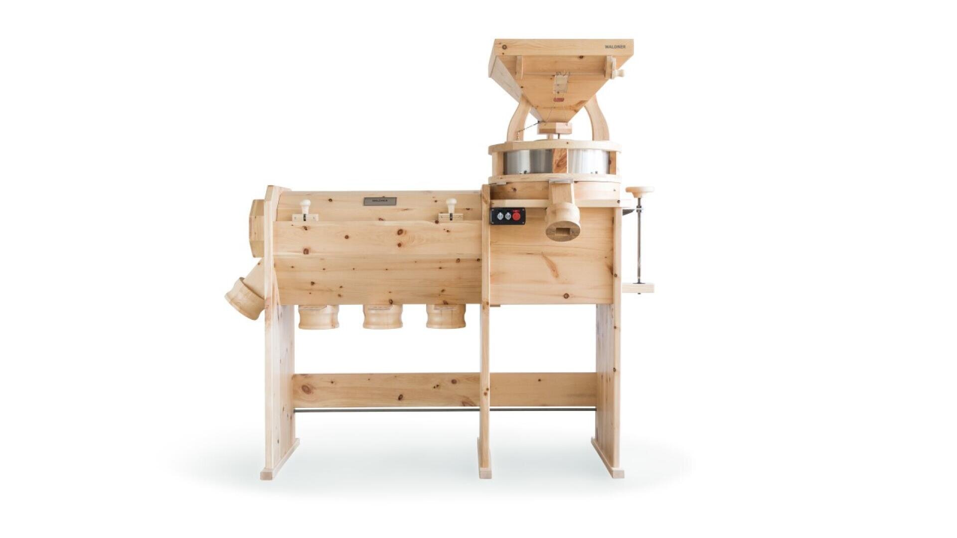 A large wooden grain mill machine with multiple compartments and chutes, used for grinding grains, stands on a white background.