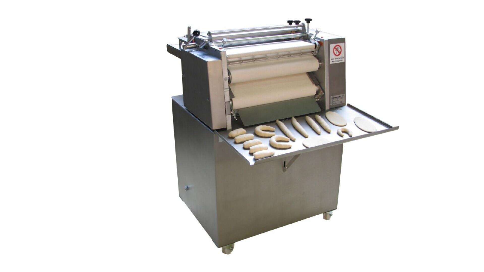 A commercial dough rolling and shaping machine with various shapes of dough pieces on a stainless steel tray attached to the front. The machine is on wheels and has a no-hand symbol for safety.