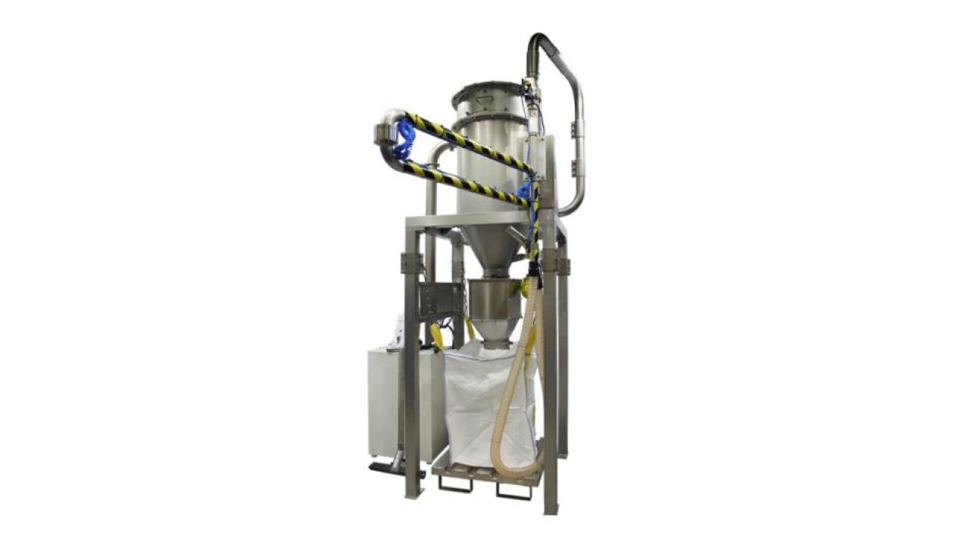 Industrial bulk bag filling machine with a large metal hopper, connected hoses, and a white bag positioned below the funnel for collecting materials. The machine is supported by a metal frame.