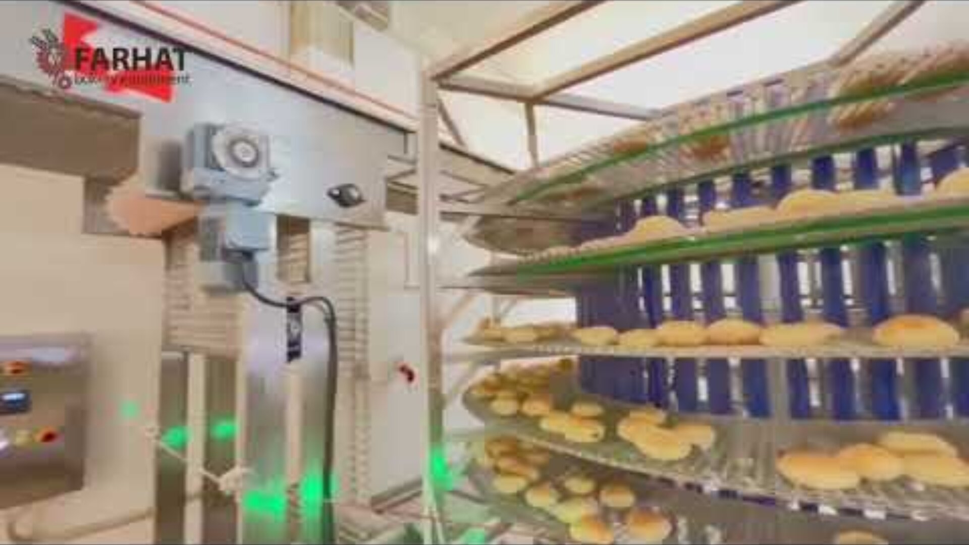 A commercial bread oven bakes rows of round buns on spiral-shaped metal racks. An industrial control panel and machinery can be seen nearby. The Farhat company logo appears in the upper left corner.
