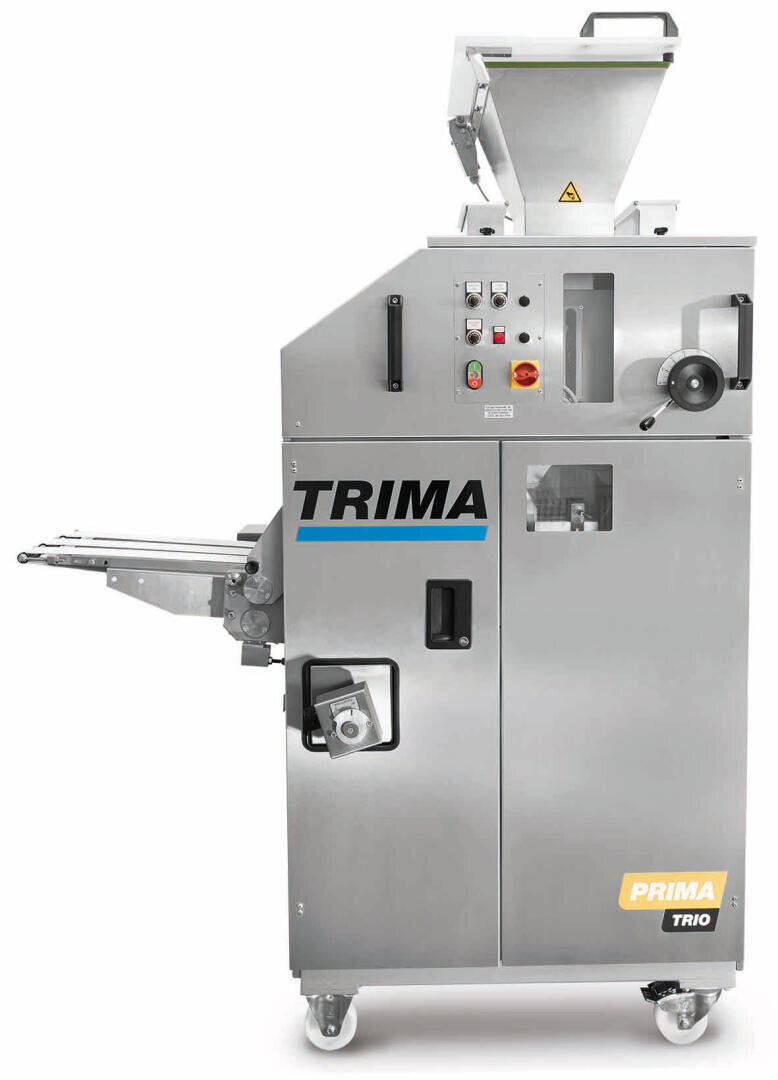 Industrial bread roll dividing and rounding machine, labeled TRIMA PRIMA TRIO, with a hopper on top, control buttons, and wheels for mobility, designed for bakery use.