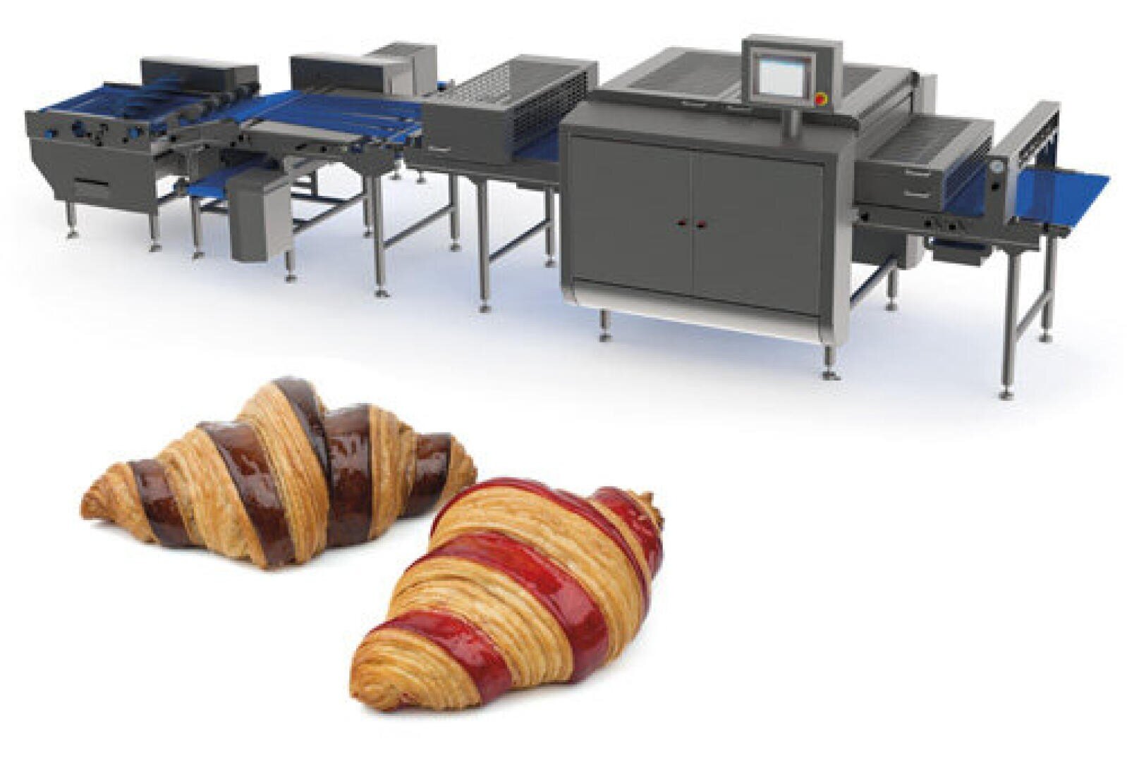 Hinter zwei Croissants mit Schokoladen- und Fruchtfüllung auf weißem Hintergrund ist eine moderne Industriemaschine zur Herstellung von Gebäck zu sehen.