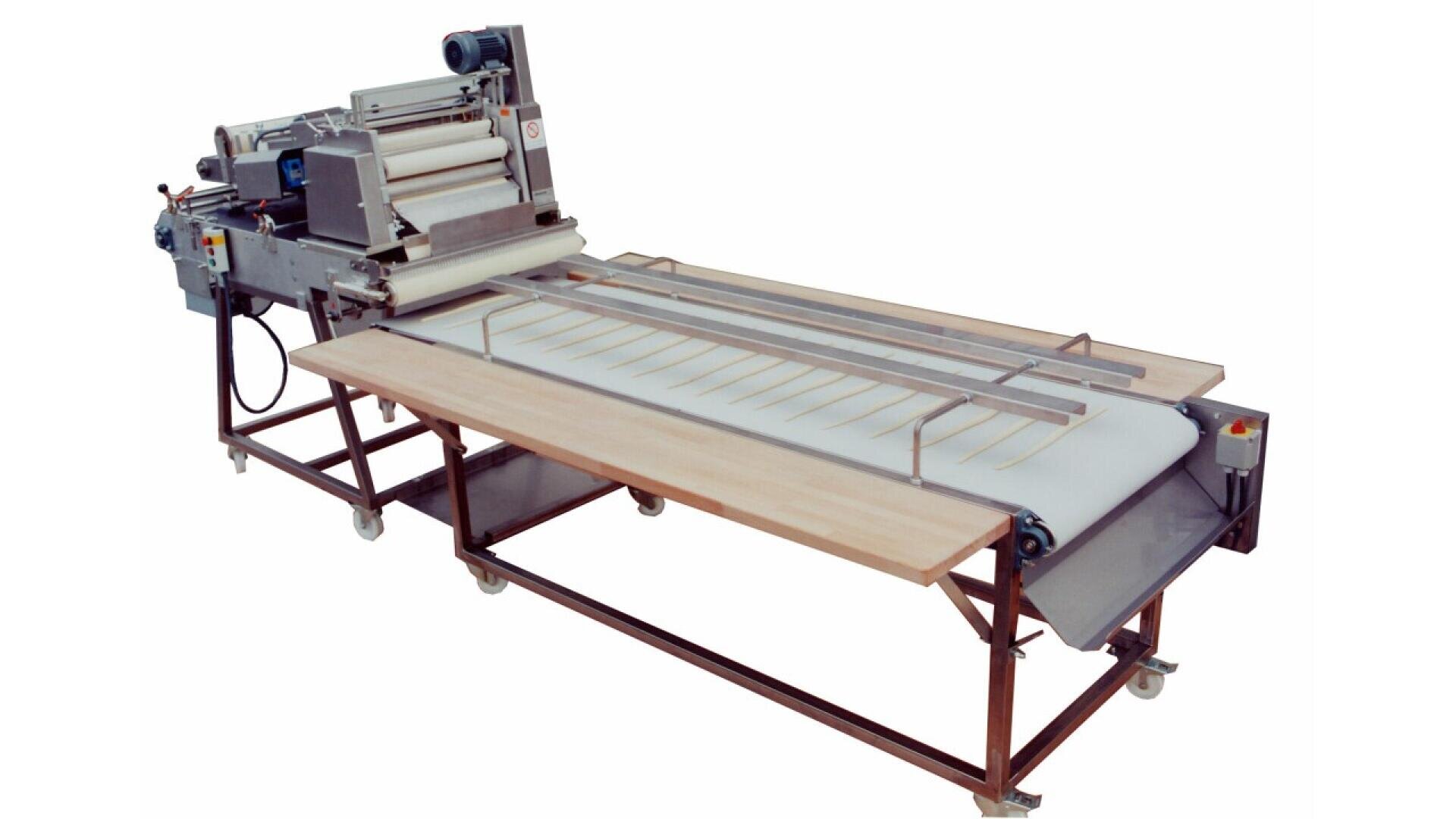 Large industrial pasta-making machine with conveyor belt and wooden table attachment, designed for rolling and cutting dough into strips. The machine is on wheels for mobility.