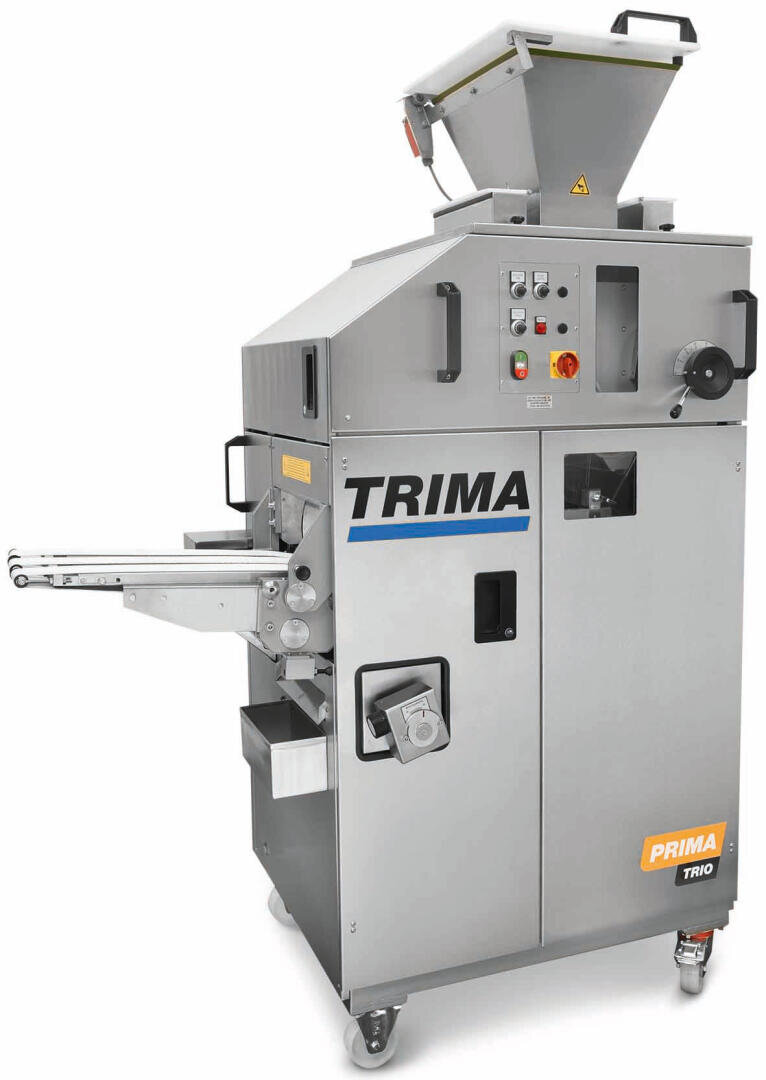 A large industrial bread roll machine labeled TRIMA Prima Trio, featuring a metal exterior, control panel, conveyor belts, and a top hopper, all mounted on wheels.