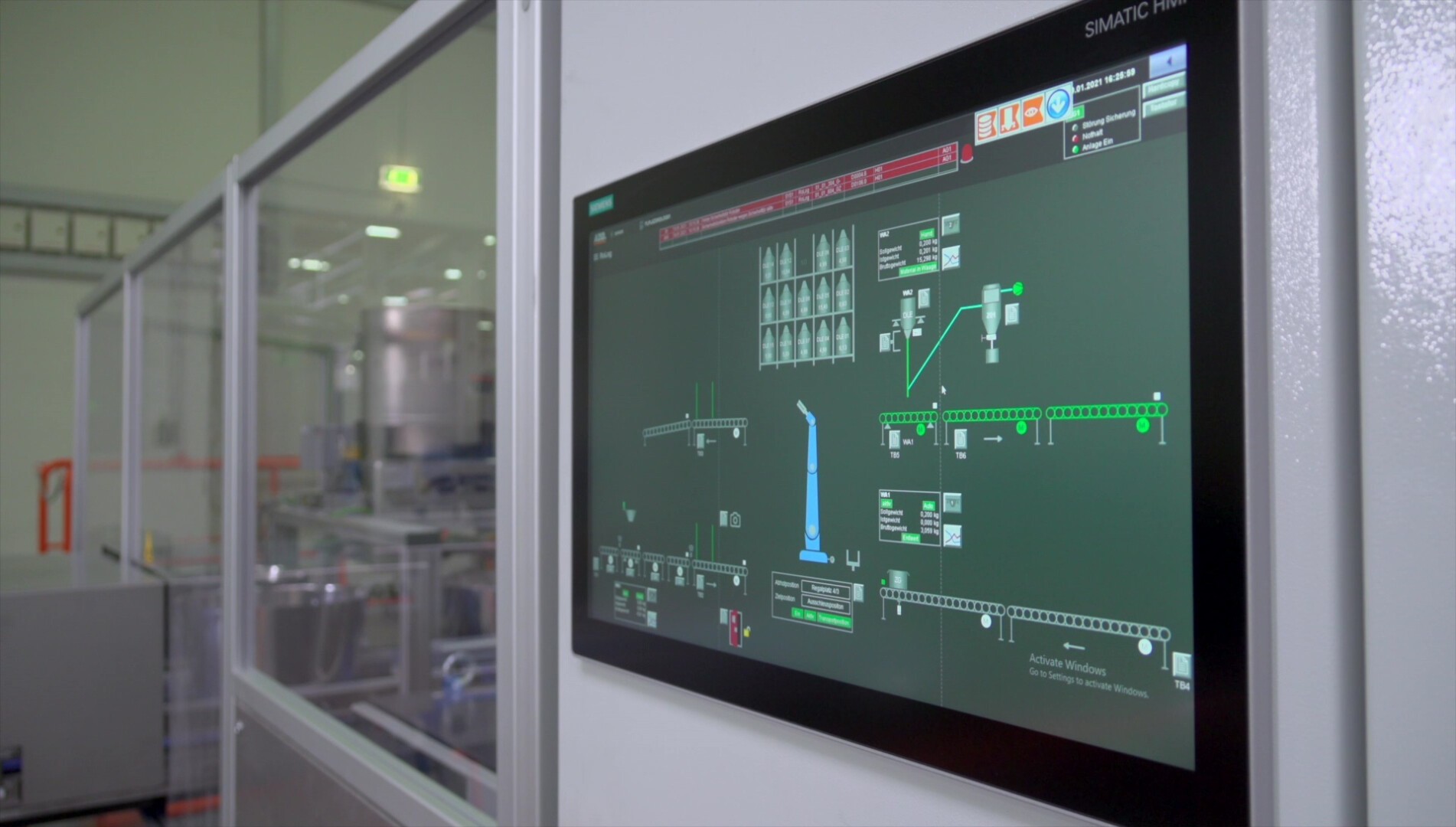 Auf einem großen Touchscreen-Bedienfeld wird ein detailliertes Industrieprozessdiagramm mit verschiedenen Linien, Symbolen und Anzeigen in einer modernen Fabrik oder Fertigungsumgebung angezeigt.